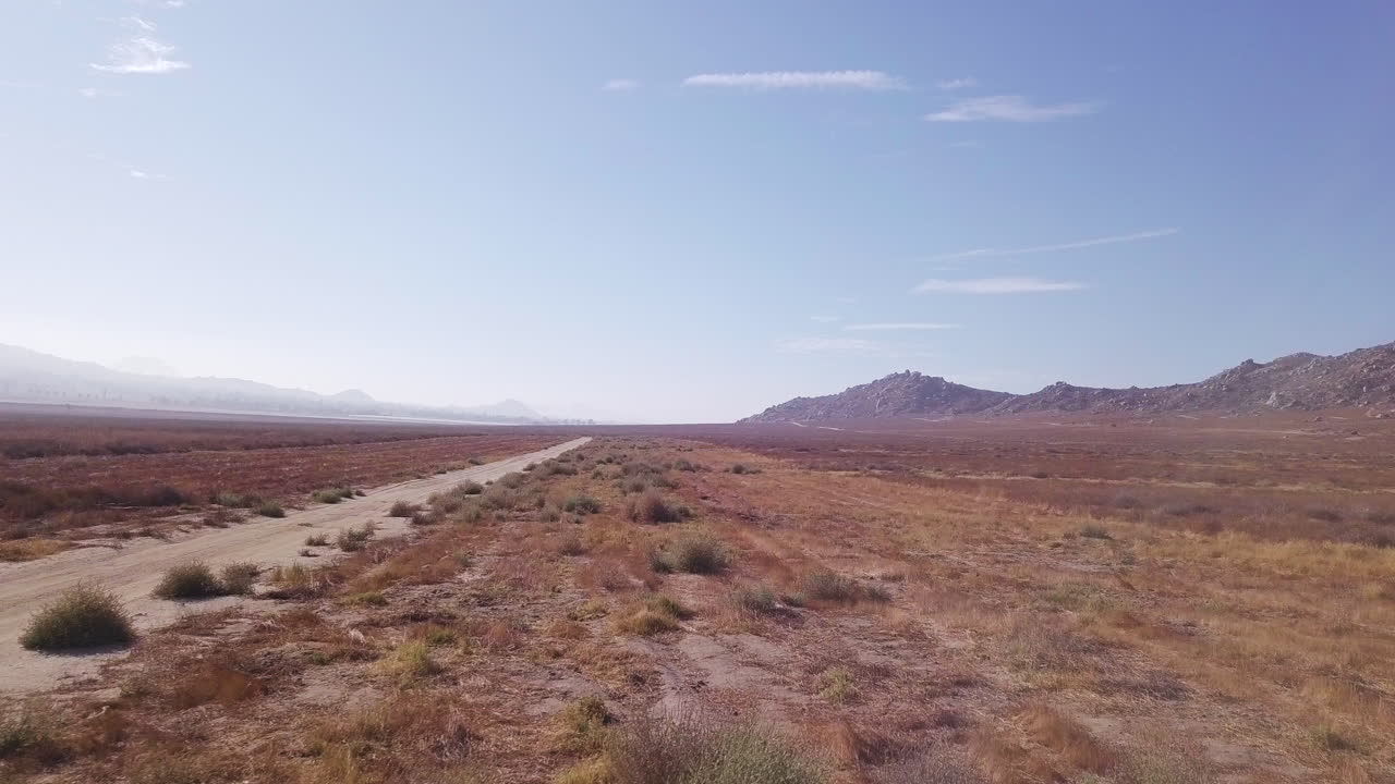 imágenes de drones al revés de una carretera polvorienta en el desierto de california