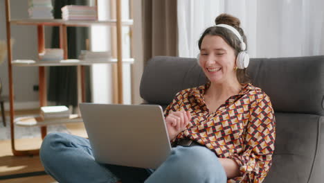 relaxed happy woman with headphones has virtual meeting on laptop