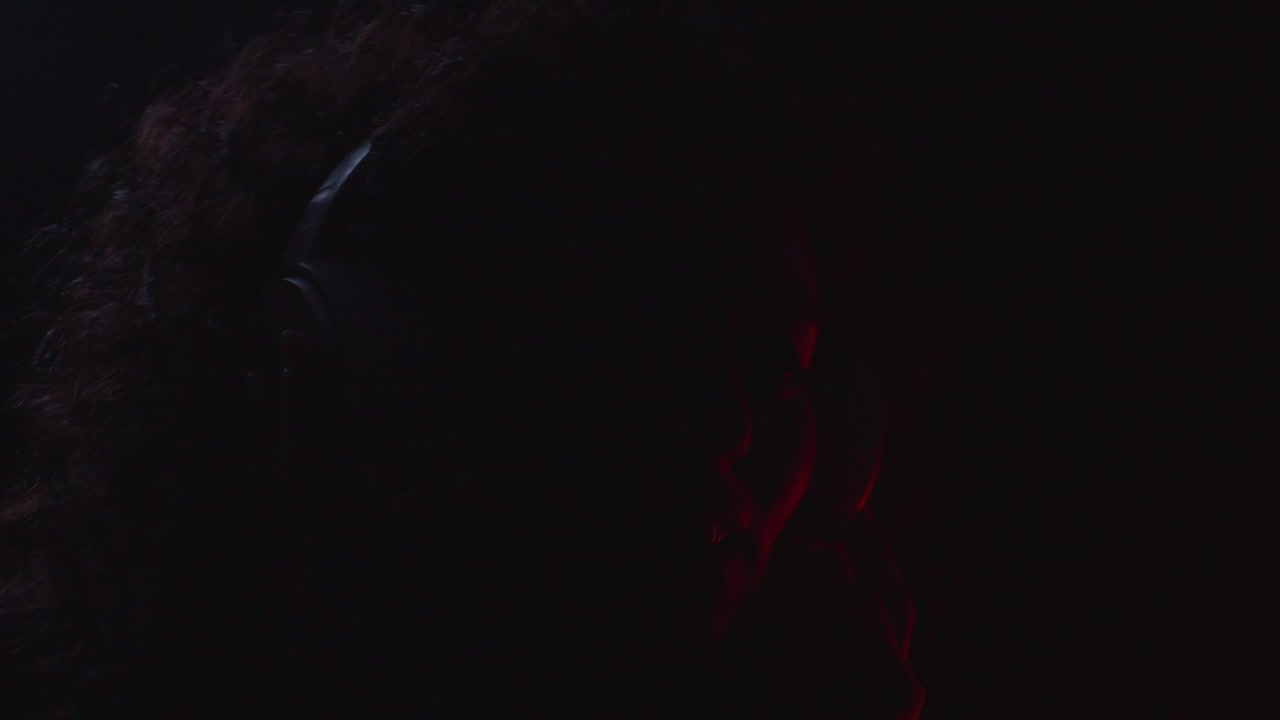 mujer feliz escucha música de audio usando auriculares modernos en la colorida luz de neón