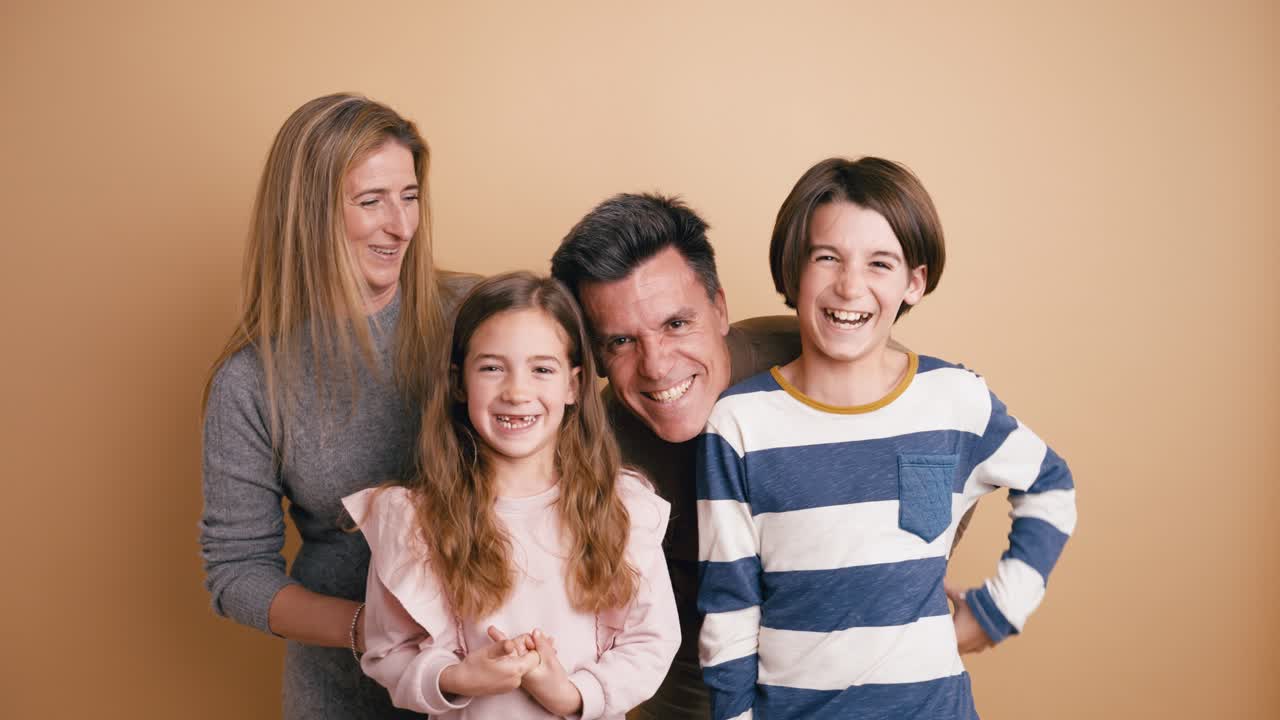 Glückliche vierköpfige Familie lächelt und lacht im Studio