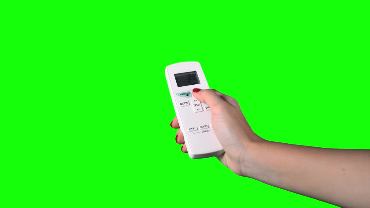 리모컨을 들고 에어컨을 켜고 있는 여성, 녹색 스크린 배경으로 촬영, 4k 해상도로 촬영