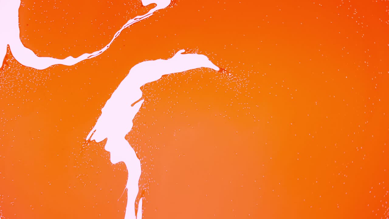 Delicious orange liquid swirling and mixing together