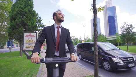 Low-Angle-Ansicht-Eines-Jungen-Mannes,-Der-Mit-Einem-Elektroroller-Durch-Die-Stadt-Fährt.