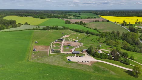 aerial drone view of small countryside zoo with animal enclosures in rural landscape. drone footage of countryside zoo nestled in green farmland