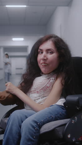 woman in wheelchair in hospital corridor