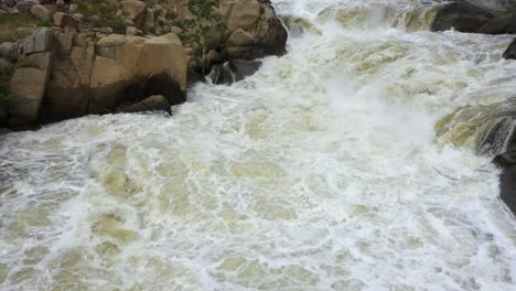 una carretilla aérea se eleva sobre las increíbles formaciones rocosas siendo envueltas en aguas de inundación corriendo en el río kern cerca del lago isabella fuera de la autopista 178 en california