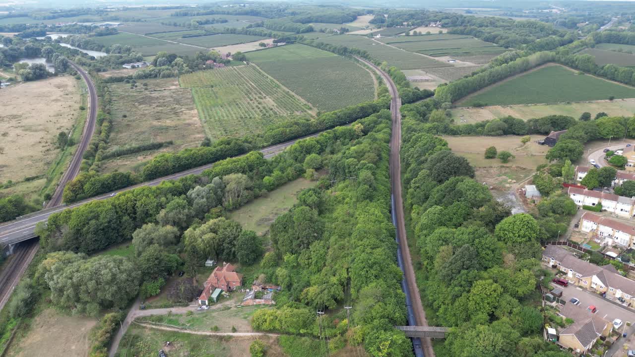 disparo de drones persiguiendo un tren ferroviario de la red azul en rápido movimiento desde canterbury y hacia una carretera de doble calzada