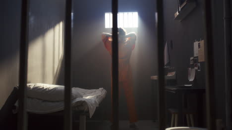remorseful inmate in orange uniform wandering around prison cell