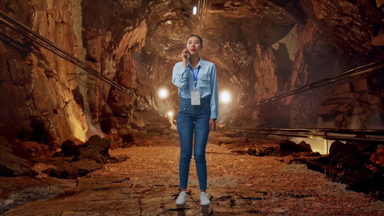 Full Body Of Asian Female In Underground Mine Tunnel, She Is Speaking With Someone In The Phone