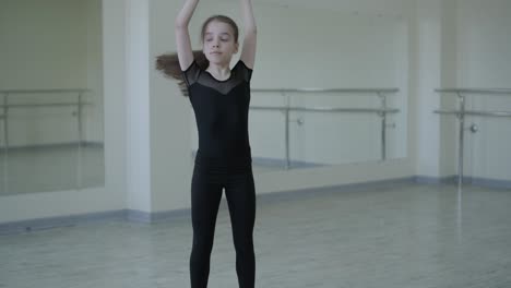 young ballerina practicing dance moves in studio