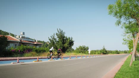 cycling together. couple of professional cyclists riding bicycle on cycle path, spending time together. friends having fun outdoors, cycling on bikes on bicycle lane, enjoying holiday weekends