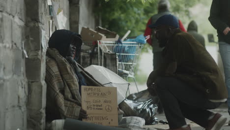 passer by supporting street beggar