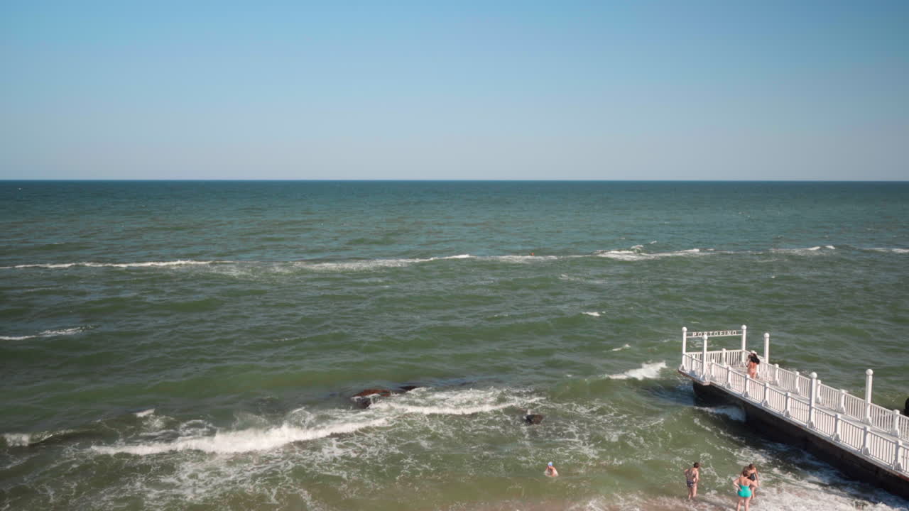Beautiful summer day at the beach with people enjoying the waves