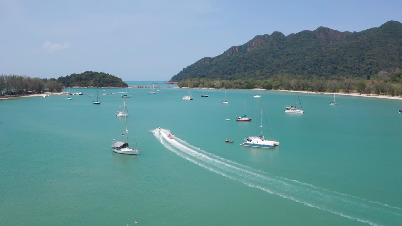 파워보트, 수상 스포츠에 부착된 고속으로 재미와 순항을 즐기는 사람들로 가득 찬 바나나 보트를 따라가는 항공 영상