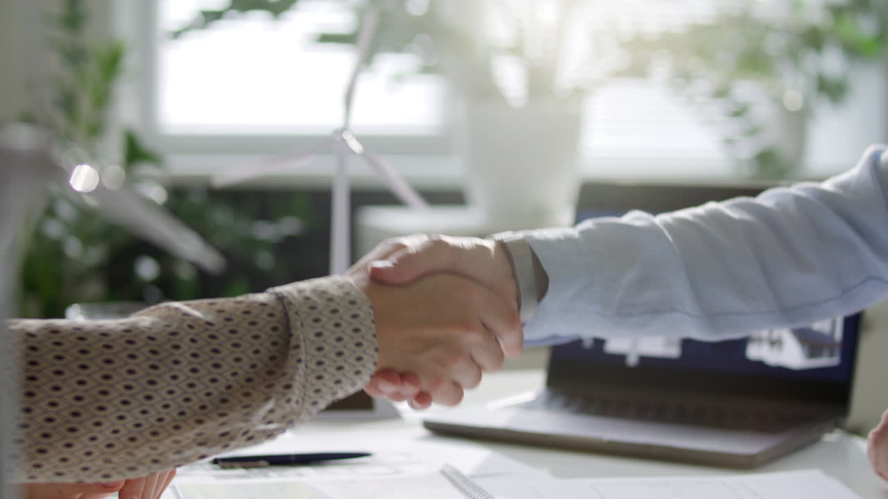 Two Sustainable Energy Engineers Sealing Agreement with Handshake