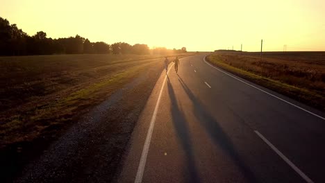 runners on a country road at sunset