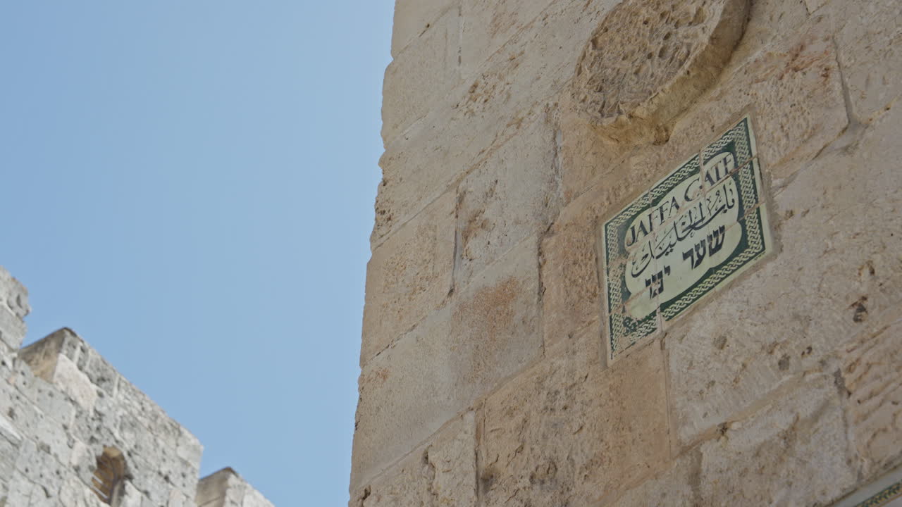 Jaffa Gate, Jerusalem, Israel, Hebrew sign on wall. Low angle wide shot. Slight pan right. 50FPS