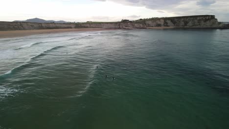 Group-of-surfers-waiting-for-ocean-wave-at-Cantabrian-Coast-Spain