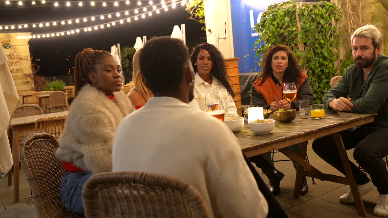 Group of people enjoying dinner together outdoors