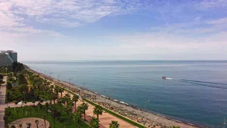 Dron-Que-Se-Aproxima-A-La-Lancha-Cerca-De-La-Playa-Y-El-Paseo-Marítimo-De-La-Ciudad