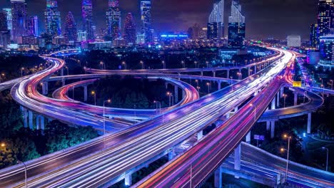 aerial view of a city highway at night with light trails, showcasing urban life