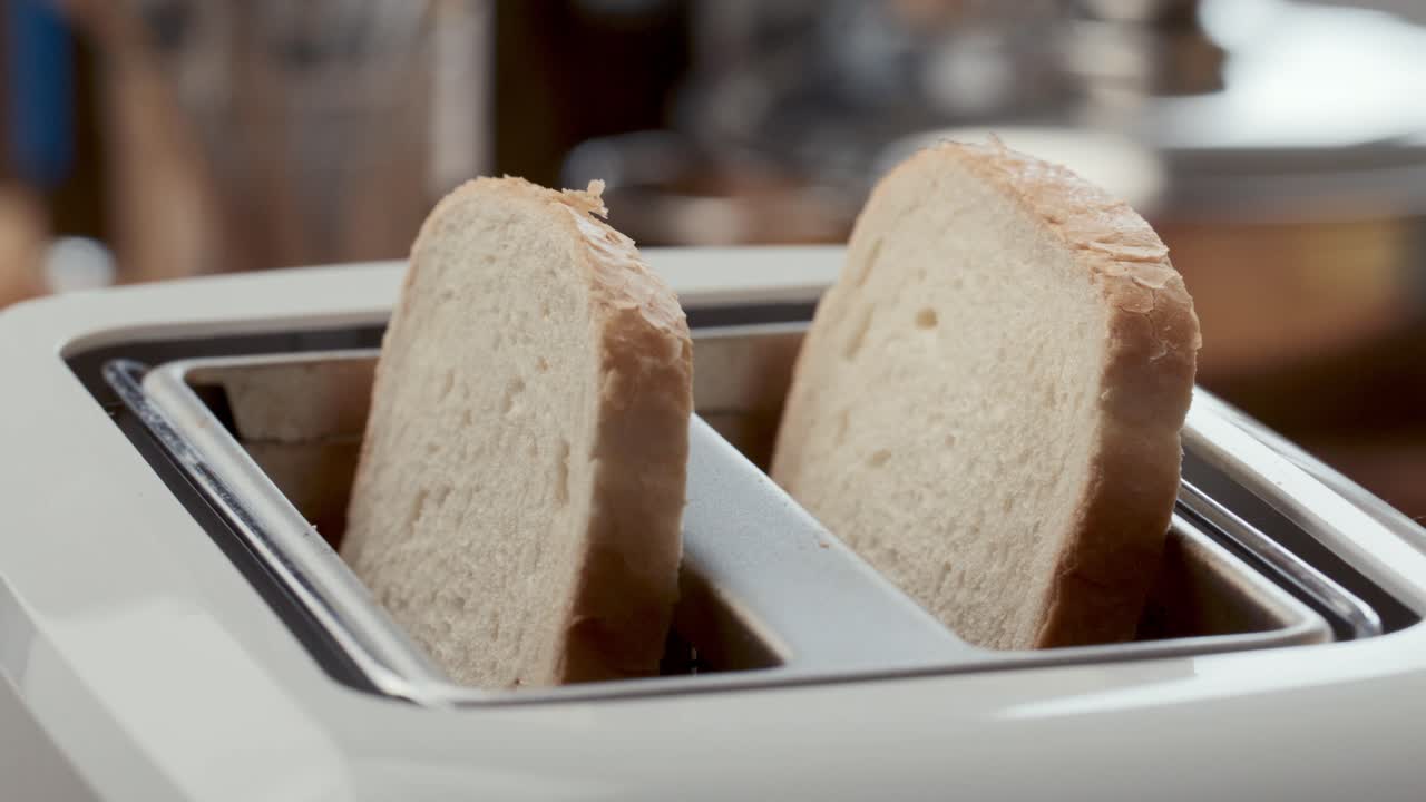 Two Slices of Bread Being Placed in Kitchen Toaster for Cooking
