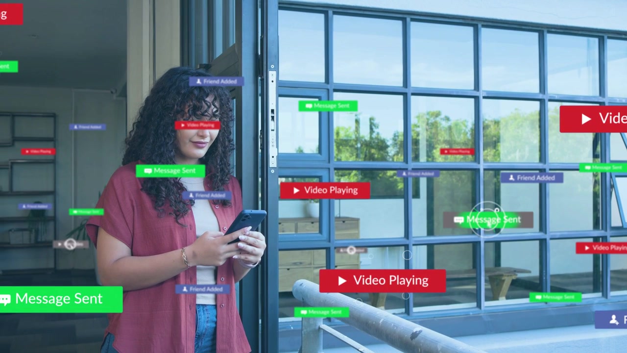 Donna che tocca il telefono vicino a una finestra a griglia, creando un'interfaccia utente fluttuante sul vetro mentre legge testi per la tecnologia
