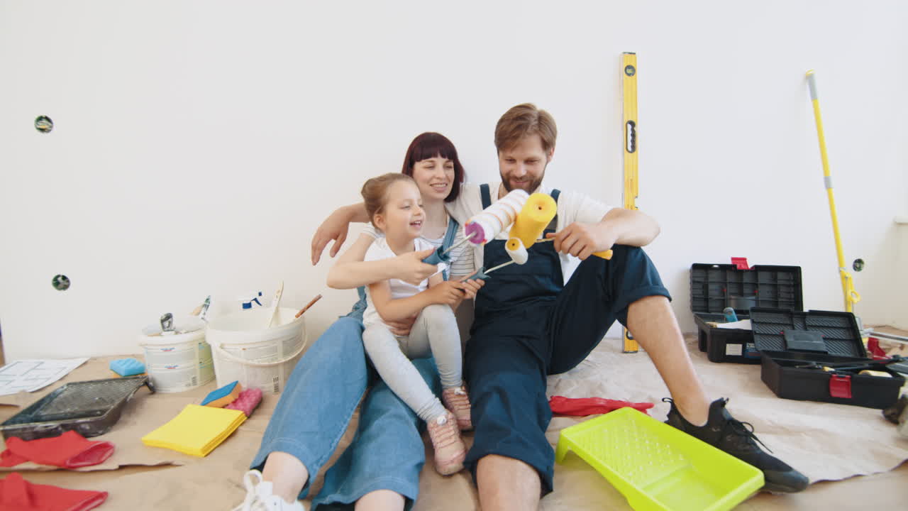 familia feliz pintando su casa