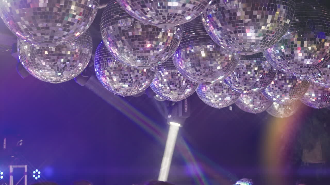 Flere discokugler reflekterer farverige lys til en fest