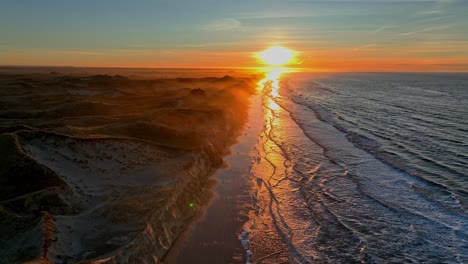 the beach is washed by sea waves, high dunes have formed, the summer house standing on the dunes is surrounded by a mystical mist, and the sun is setting on a winter evening