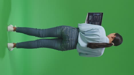 back view of full body asian business woman using laptop computer on green screen background in the studio, computer display showing code