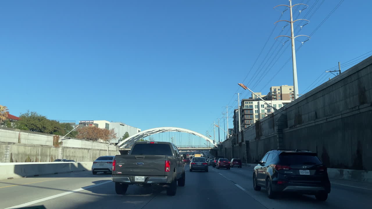 POV look driving car on Houston freeway at rush hour in the evening. Driver View Driving car on Texas Interstate highway 45. Stuck in slow traffic traveling through Houston urban area. Traffic jam.
