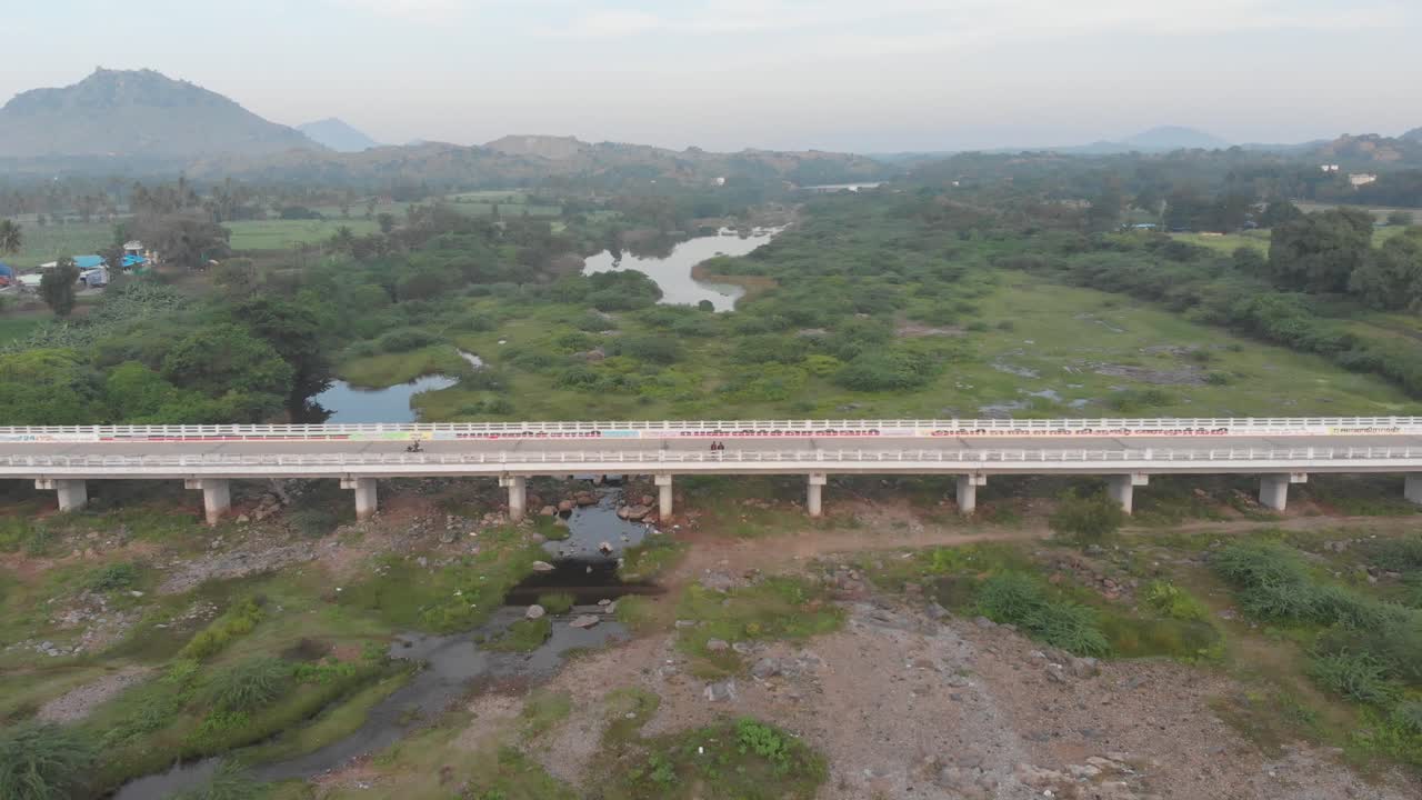 puente del pueblo de kolamanjanur por exuberantes verdes y estanques en la india rural