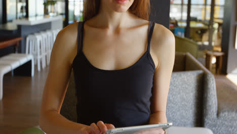 Front-view-of-young-caucasian-businesswoman-working-on-digital-tablet-in-a-modern-office-4k