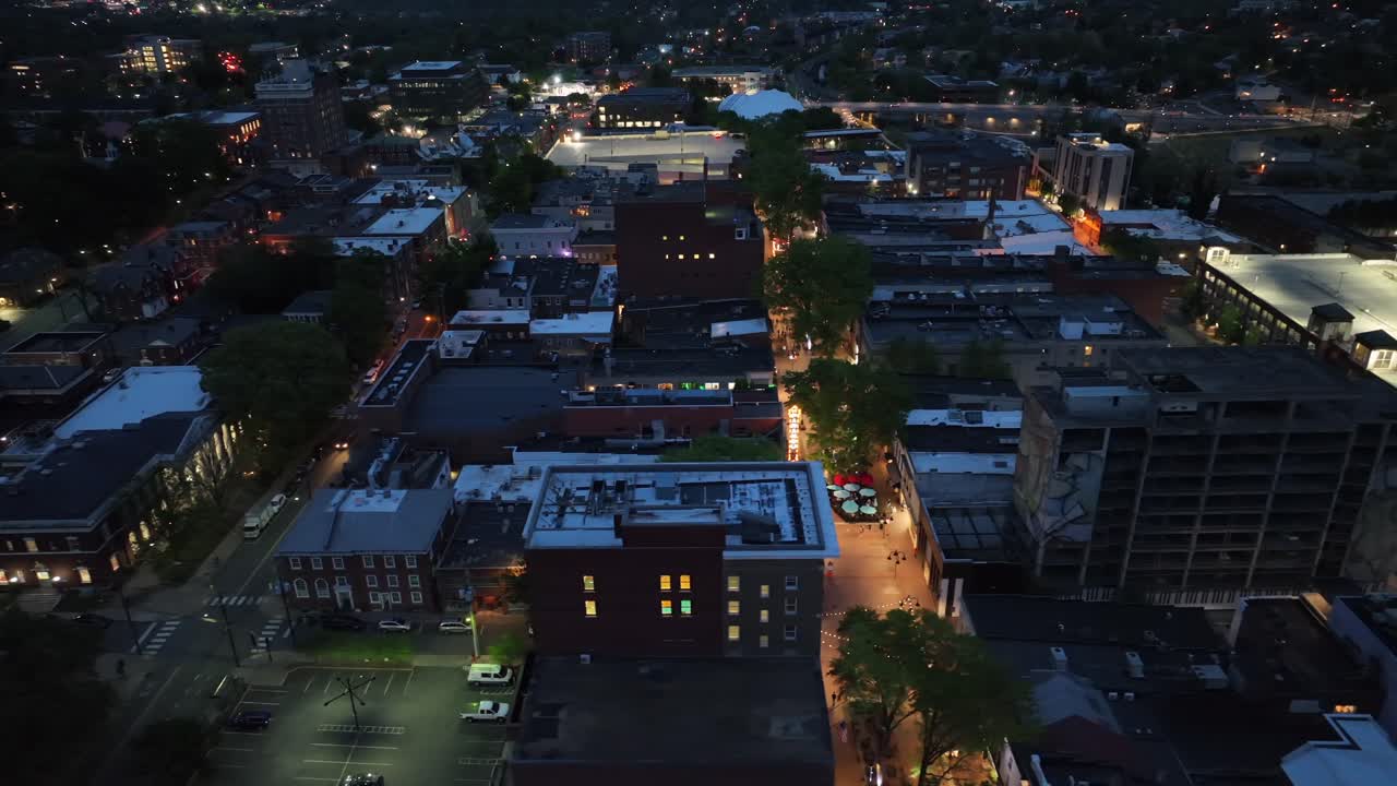 Small American town lighting at night. Charlottesville town from above, Virginia, USA. Aerial top down shot. Illuminated Shopping street in downtown.