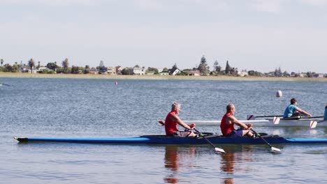 Four-senior-caucasian-men-and-women-rowing-boat-on-a-river