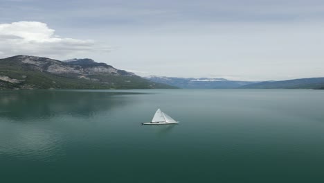 Sailing-Boat-on-the-lake-in-front-of-a-small-village-in-Gäsi-Betlis,-Walensee-Glarus,-Weesen-Walenstadt,-Switzerland