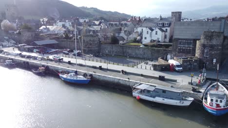 idílico castillo de conwy y el puerto de la ciudad pesquera barcos en la costanera antena baja tire a la derecha