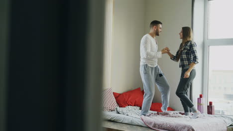 una pareja bailando en la cama.