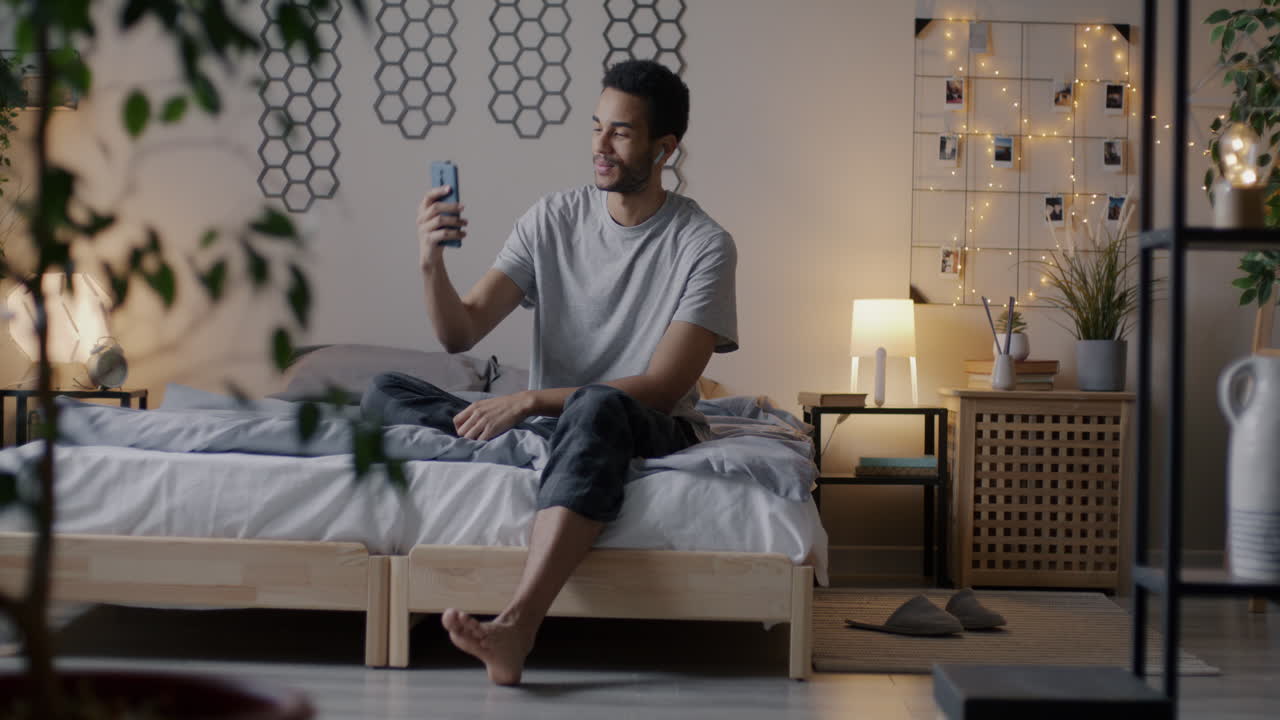 Uomo in videochiamata in camera da letto