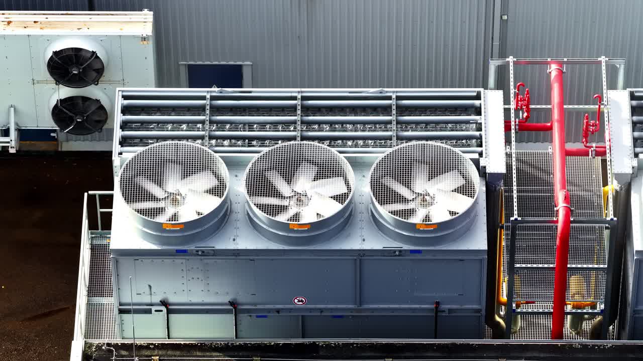 Aerial view of industrial cooling unit fans and HVAC equipment on a rooftop