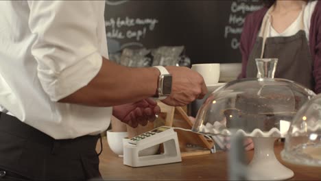 hombre pagando por cafe en cafe