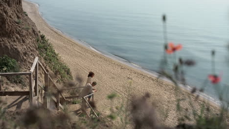 Relaxed-lovers-watching-amazing-seascape-standing-beach-stairway-in-distance.