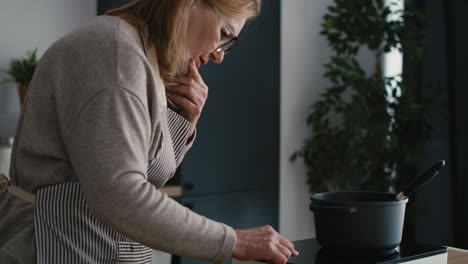 caucasian senior woman having problem with electronic oven usage