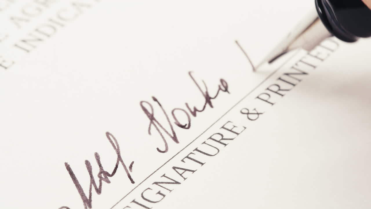 Close-up of Hand Signing a Document with a Fountain Pen