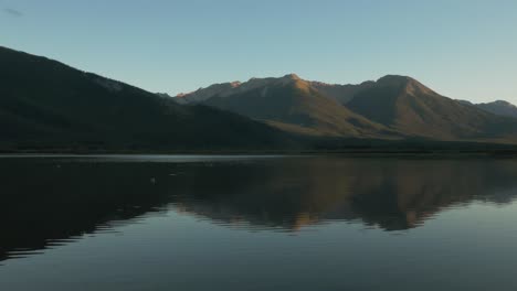 pan of vermillion lakes in front of mount rundle during sunset on a clear summer day