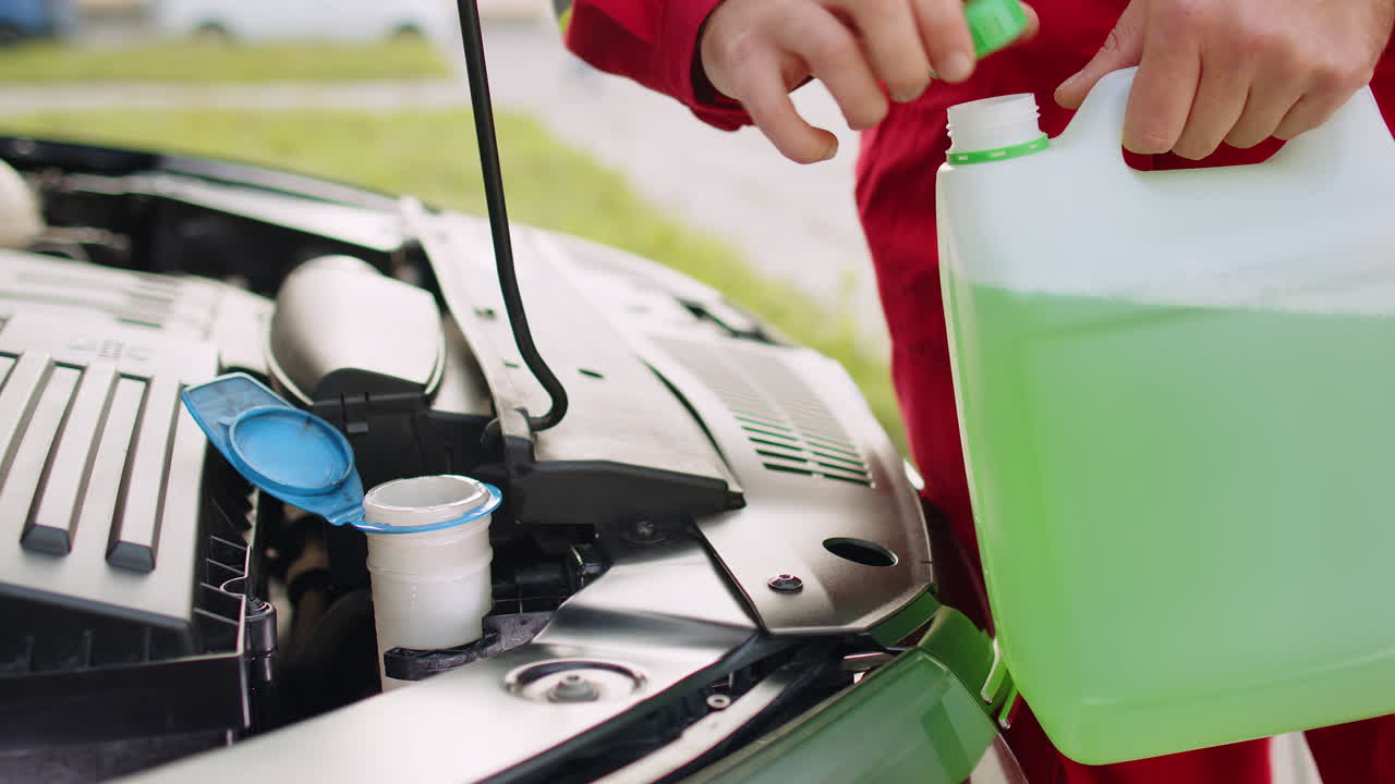 서비스 노동자 남자가 차 액체를 부어 차 앞 유리 유리 녹색 세탁기 유리 청소기 여름 겨울 액체