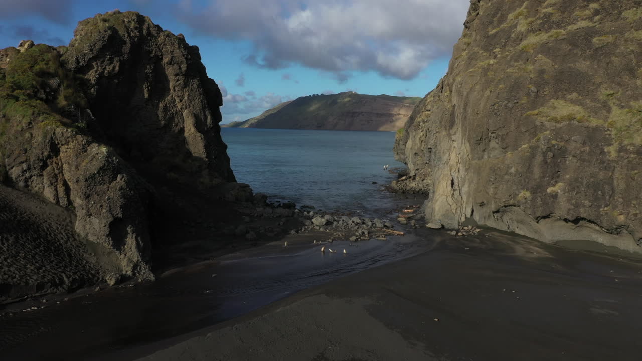 pasaje en la playa de whatipu rodeada de formaciones de acantilados hacia las cabezas de manukau