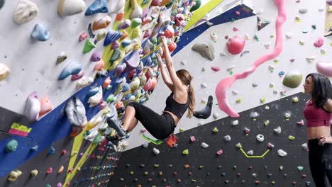 Frauen-Klettern-Boulderwand-Mit-Bunten-Griffen