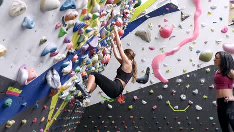 mujeres escalando la pared de rocas con mangos coloridos